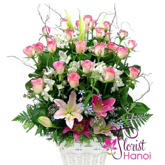 Beautiful pink roses arrangement with pink lilies and white alstroemeria in a white basket