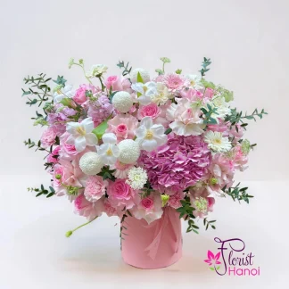 Pink flower arrangement with hydrangea orchids and roses in a floral box