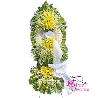 White orchid and yellow lily funeral flower arrangement in Hanoi