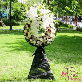 Sympathy flower arrangement for funeral with white orchids and roses